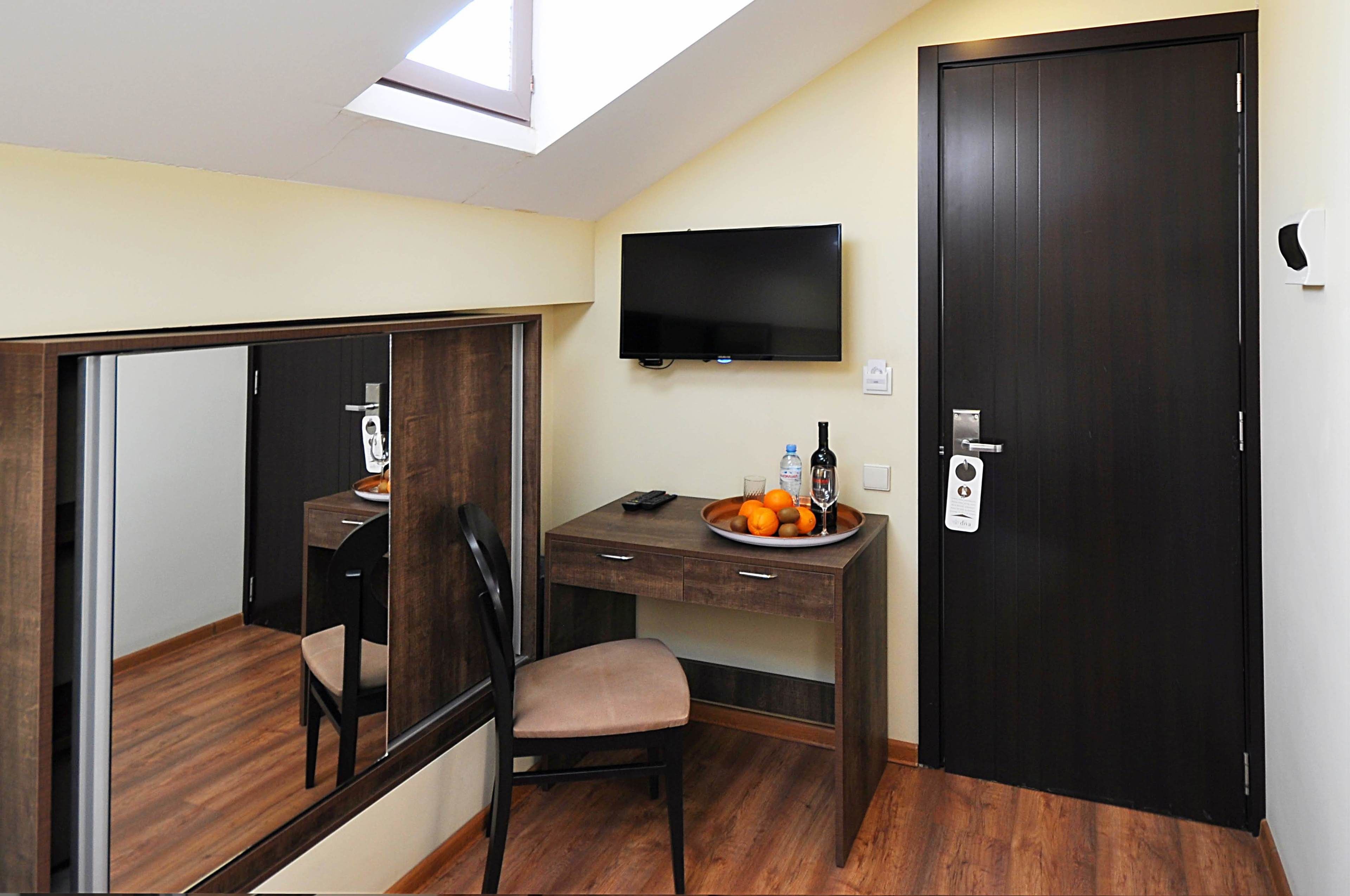 Una habitación compacta con escritorio, silla y televisor montado en la pared.
