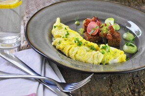 Ein Teller mit einem Omelett, Fleisch und Gemüse.