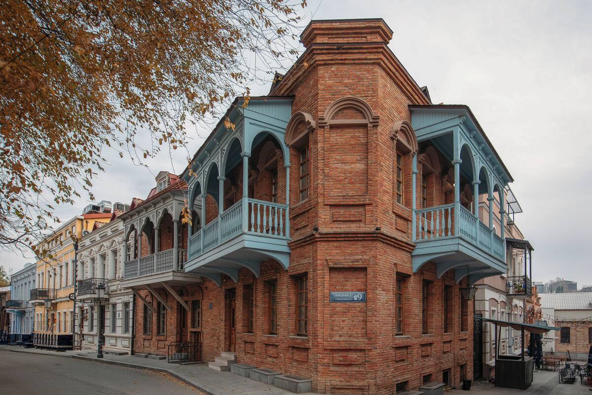 A historic building with a prominent corner balcony and a sign indicating it is number 9.