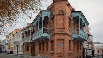 Un edificio histórico con un balcón prominente en la esquina y un cartel que indica el número 9.