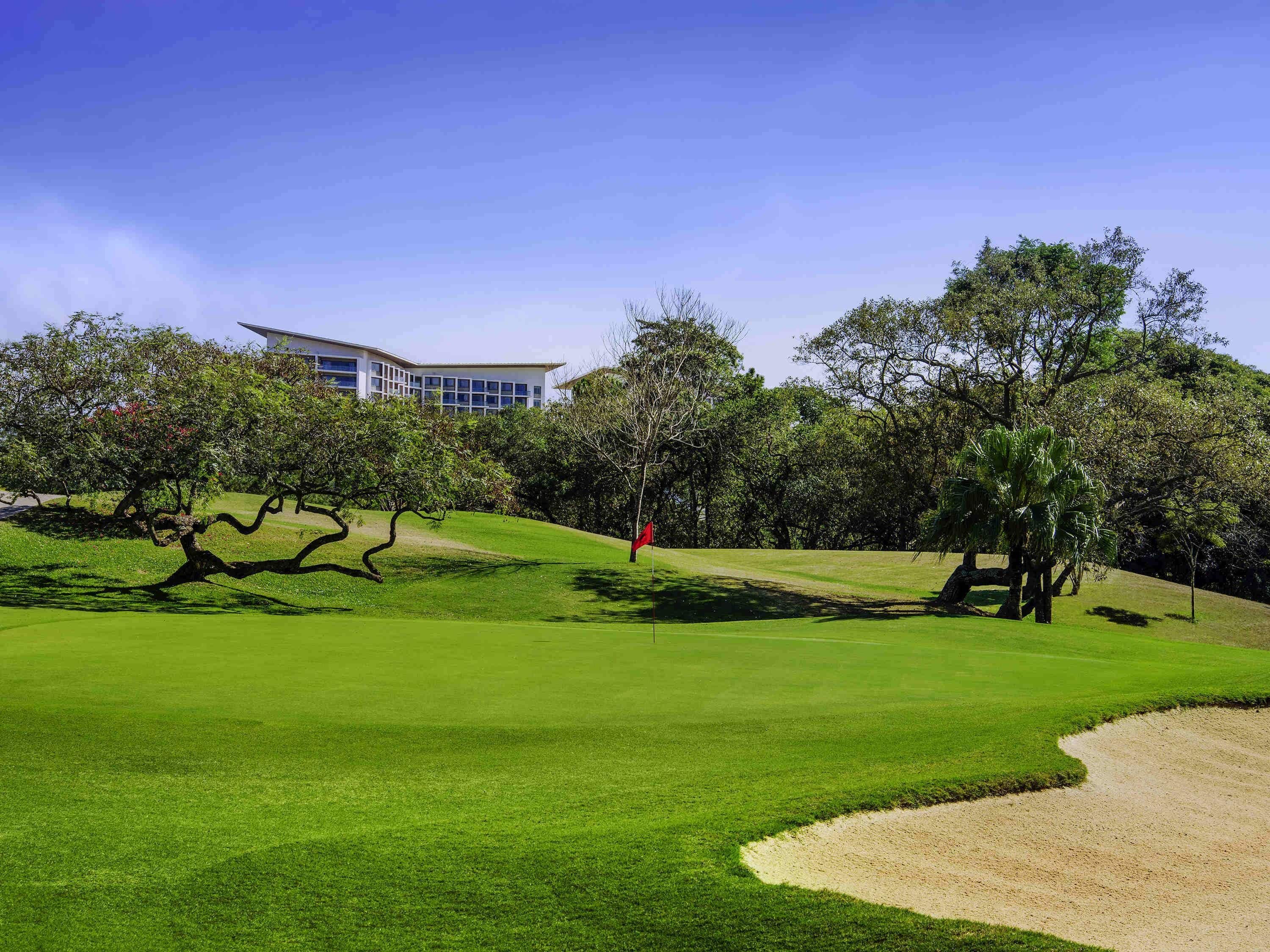 A golf course with a building in the background.