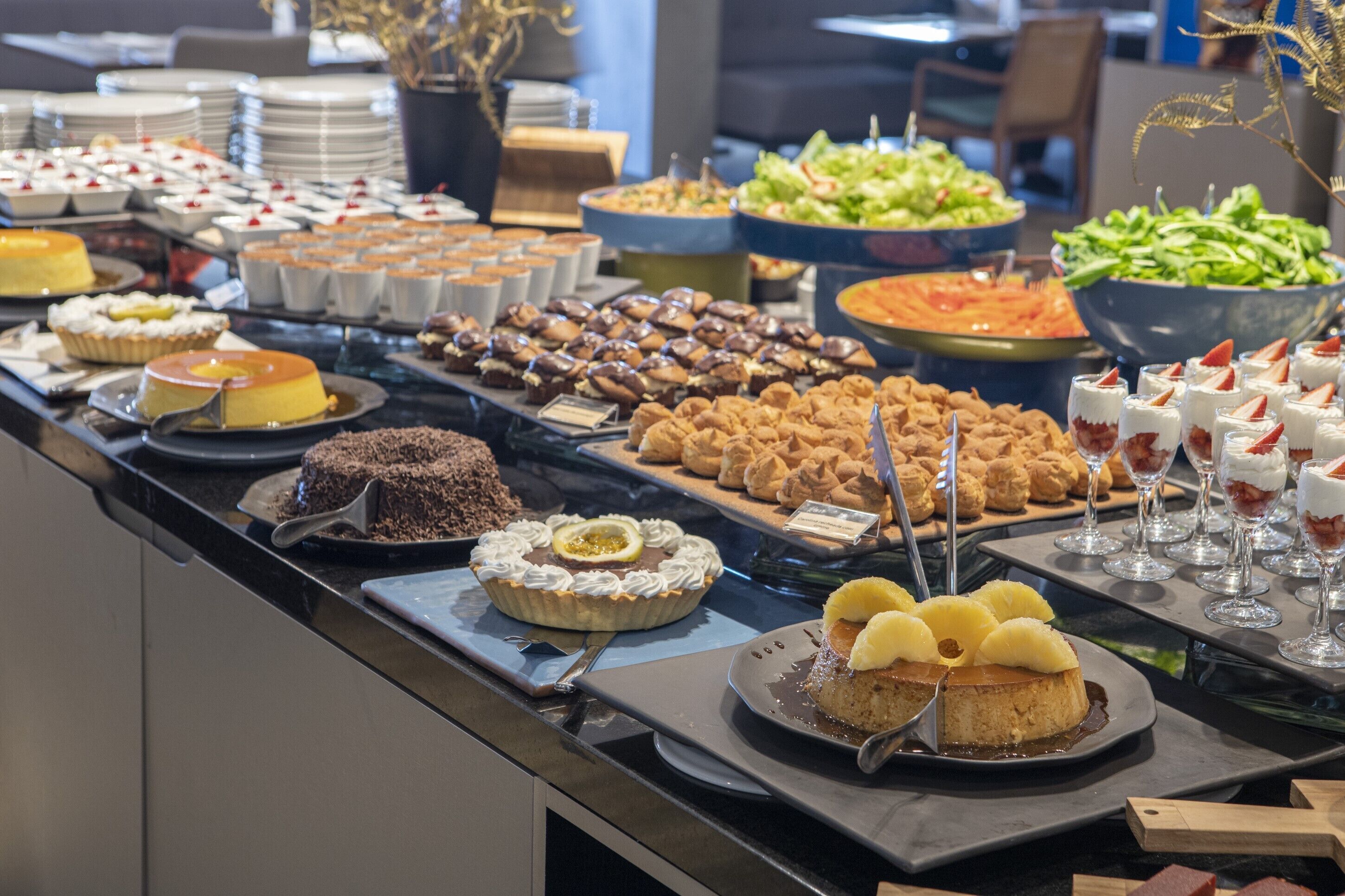 A buffet with various desserts and salads.