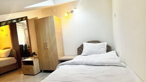 A bedroom with a bed, a wardrobe, a bedside table, and a lamp. - Apartments Marinero (Kotor)
