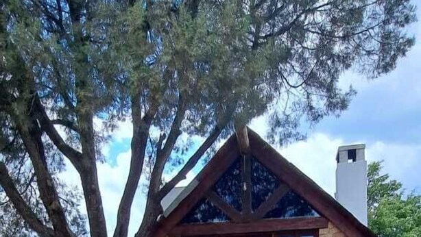 A rustic stone building with a large tree in front, a stone pathway, and a clear sky. - Hotel Kuautli (Huasca de Ocampo)