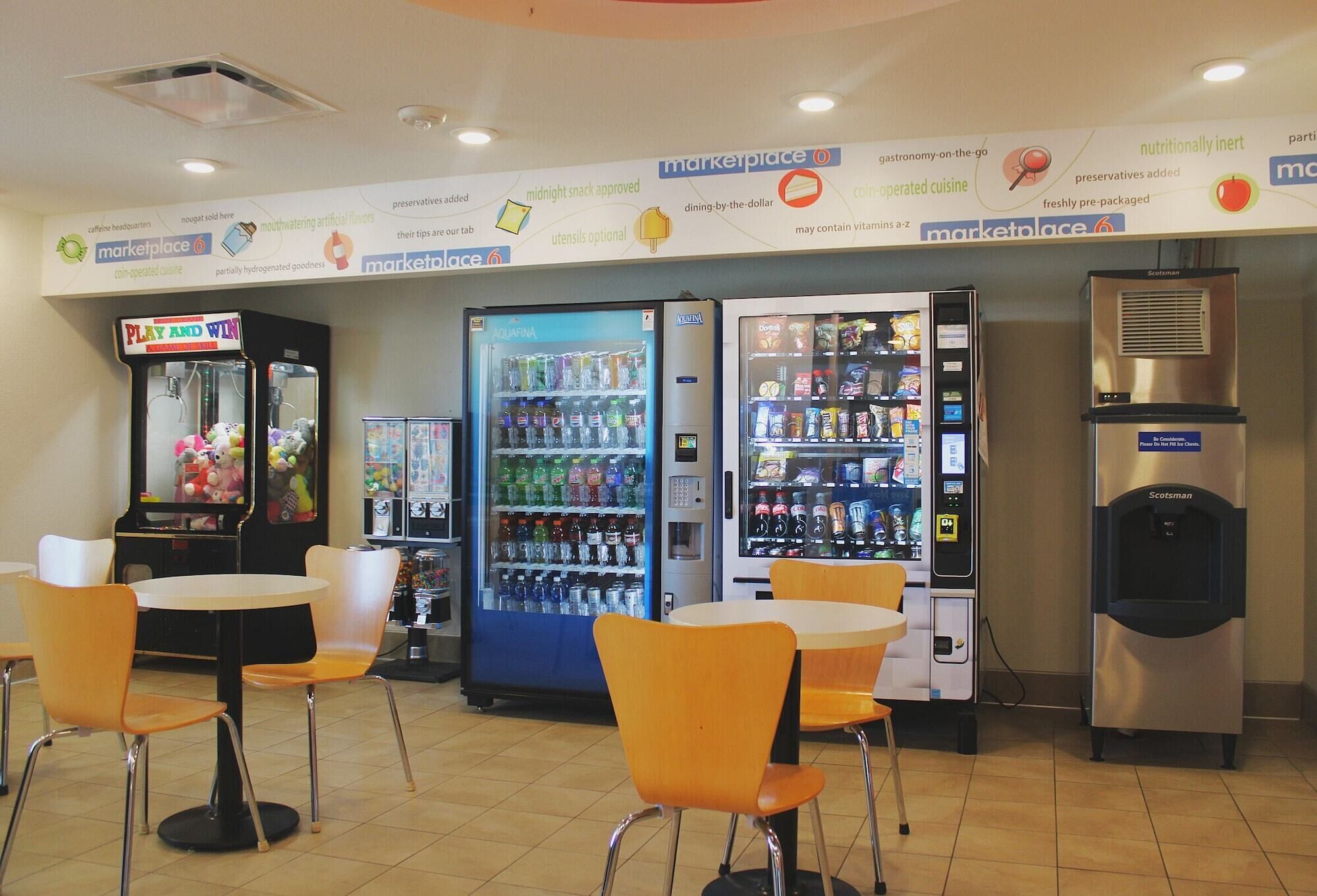 A food court with vending machines, a Play and Win game machine, and a Scotman refrigerator.