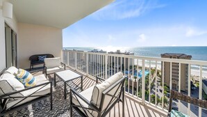 A balcony with a view of the ocean and a pool area. - Gulf Views - Sleeps 6 | Gulf Shores | Direct Beach Access (Gulf Shores)