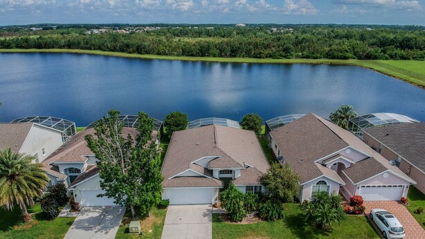 Un quartier résidentiel avec des maisons, un lac et un ciel dégagé.