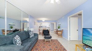 A living room with a grey sofa, a patterned rug, and a television on a stand. - Slice Of Paradise (Sanibel)