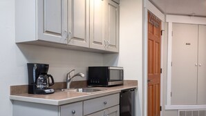 A compact kitchen with white cabinets, a coffee maker, a microwave, and a dishwasher. - Cozy Hotel Suite-Block from Main Street and Lift I Managed by Park City Lodging (PARK CITY)