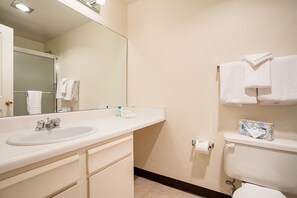 A bathroom with a sink, mirror, toilet, and towel rack.