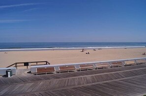 Une plage avec une promenade en bois et des bancs.