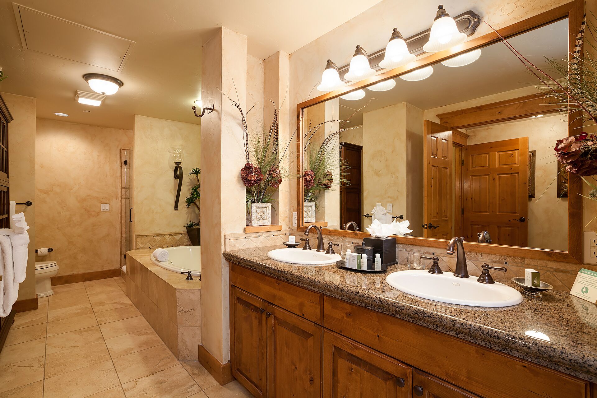 A bathroom with two sinks, a large mirror, and a shower.