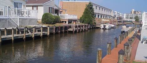 A canal with wooden walkways, a water tower, and row houses along the water.