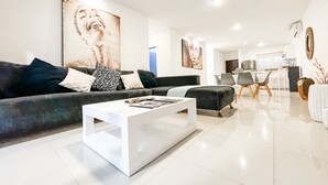A modern living room with a sofa, coffee table, and artwork on the walls. - Incredible- Fully funrished & equipped+ pool view - 1 block from 5th (Playa del Carmen)