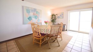 A dining area with a table, chairs, and a vase of flowers.