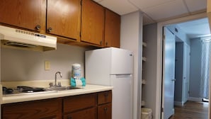 Una cocina con armarios de madera, un refrigerador blanco, una estufa y un lavamanos.