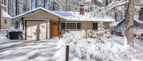 Une maison de plain-pied avec un garage, une porte d’entrée et un petit porche.