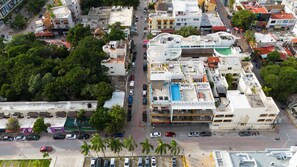 An aerial view of a densely packed urban area with buildings, roads, and parked cars.
