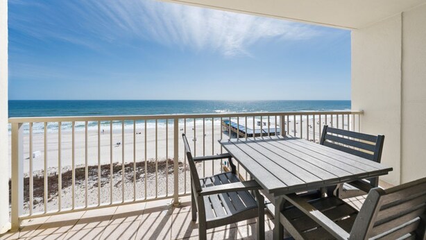 Ein Balkon mit Blick auf Strand und Meer.