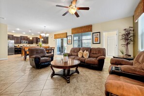 A spacious living area with a dining table, two sofas, and a coffee table. - Champions Gate Pool Home | 3 King Suites | Game Room | Dog Friendly (Champions Gate)