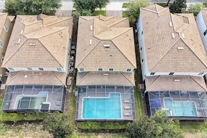 A row of residential buildings with tiled roofs and swimming pools. - Champions Gate Pool Home | 3 King Suites | Game Room | Dog Friendly (Champions Gate)