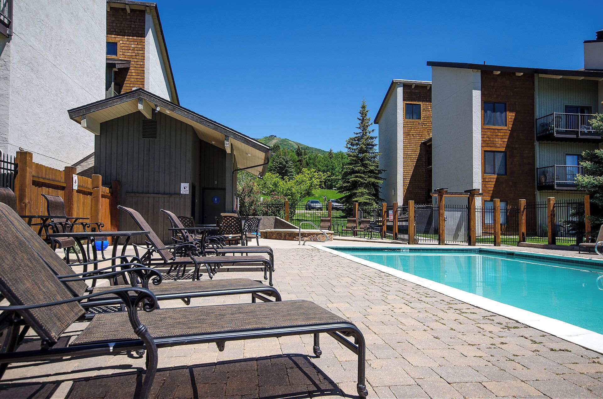 A poolside area with lounge chairs and a pool.