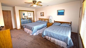A bedroom with two beds, a ceiling fan, a mirror, and a window with blinds. - Fountain Road 13701-Bayside 137th St, W/D, AC (Ocean City)