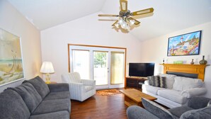 A living room with a ceiling fan, a TV, and two sofas. - Fountain Road 13701-Bayside 137th St, W/D, AC (Ocean City)