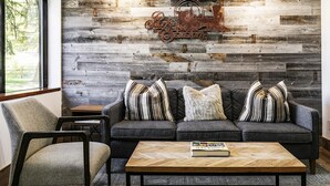 Een moderne woonkamer met een grijze bank, gestreepte kussens en een houten salontafel.