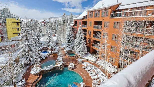 A resort with a pool area surrounded by snow-covered trees and buildings. - River Run Village Walk To Gondola Pool Hot Tubs Restaurants and Shops DELUXE (Keystone)