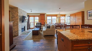 A spacious living area with a fireplace, a sofa, and a dining table. - River Run Village Walk To Gondola Pool Hot Tubs Restaurants and Shops DELUXE (Keystone)