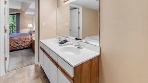 Un baño con un espejo grande, dos lavamanos y un mueble de tocador.