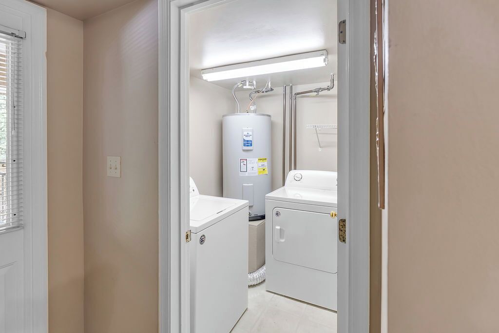Un lavadero con calentador de agua, lavadora y secadora.