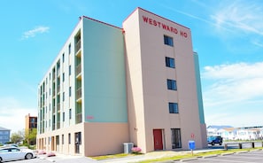 Un hôtel à plusieurs étages, avec une façade beige et bleu clair, un toit rouge et l’inscription « WESTWARD HO » sur le dessus.