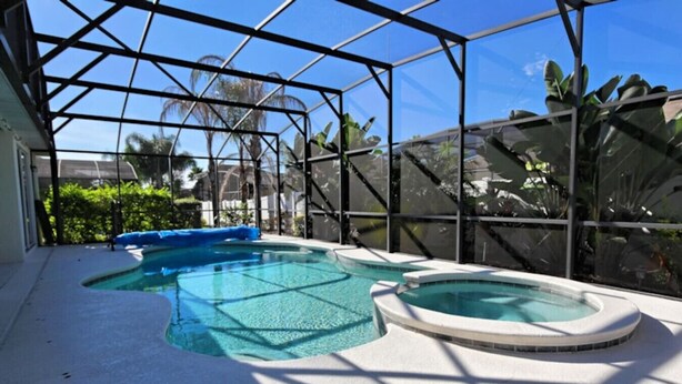 An indoor swimming pool with a glass ceiling, surrounded by tropical plants. - Rivendell: Private Pool/Spa with 24/7 Support! (Davenport)