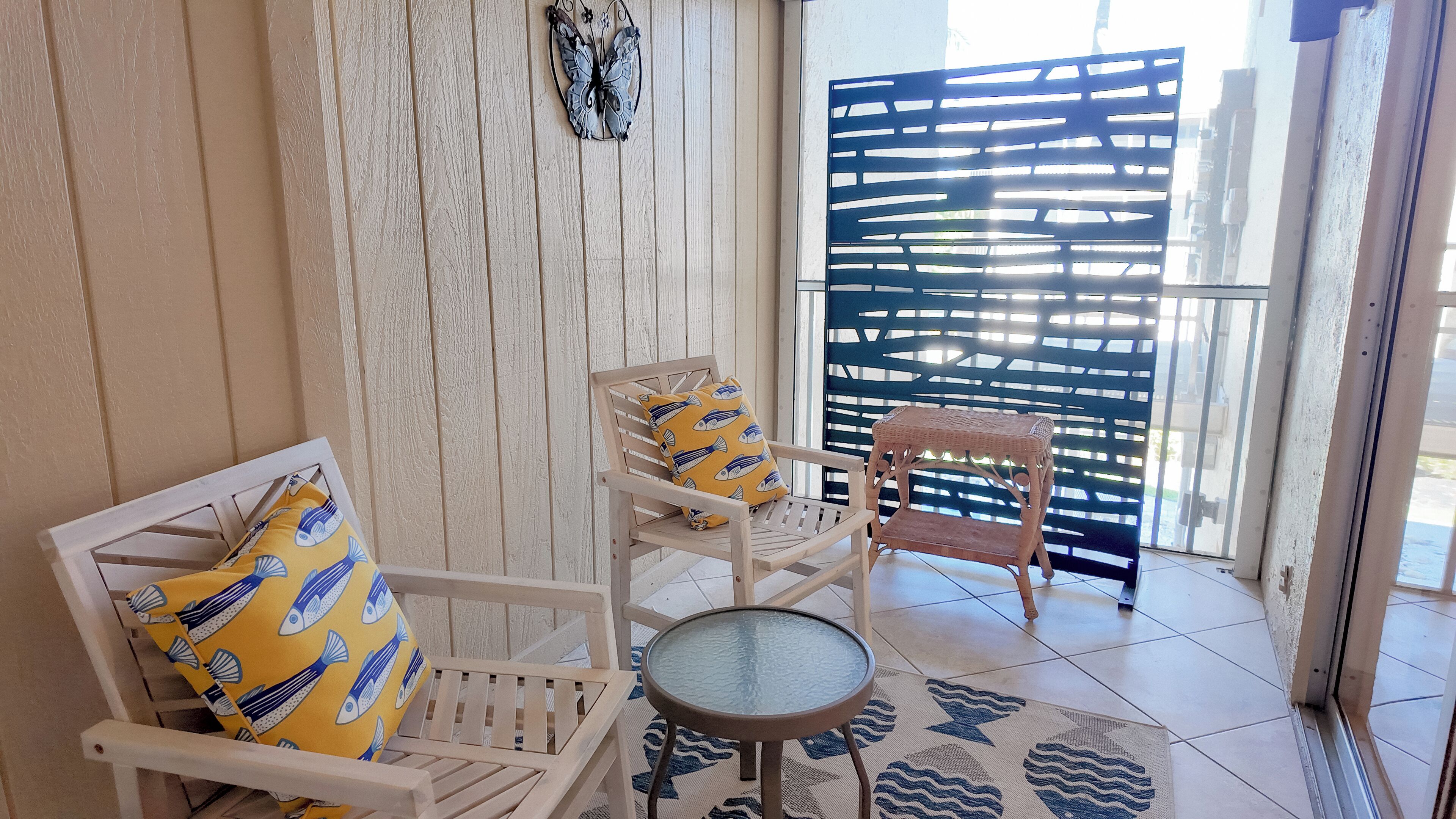 Une pièce avec un banc en bois, une petite table ronde et un tapis à motifs.
