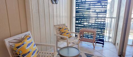 Une pièce avec un banc en bois, une petite table ronde et un tapis à motifs.
