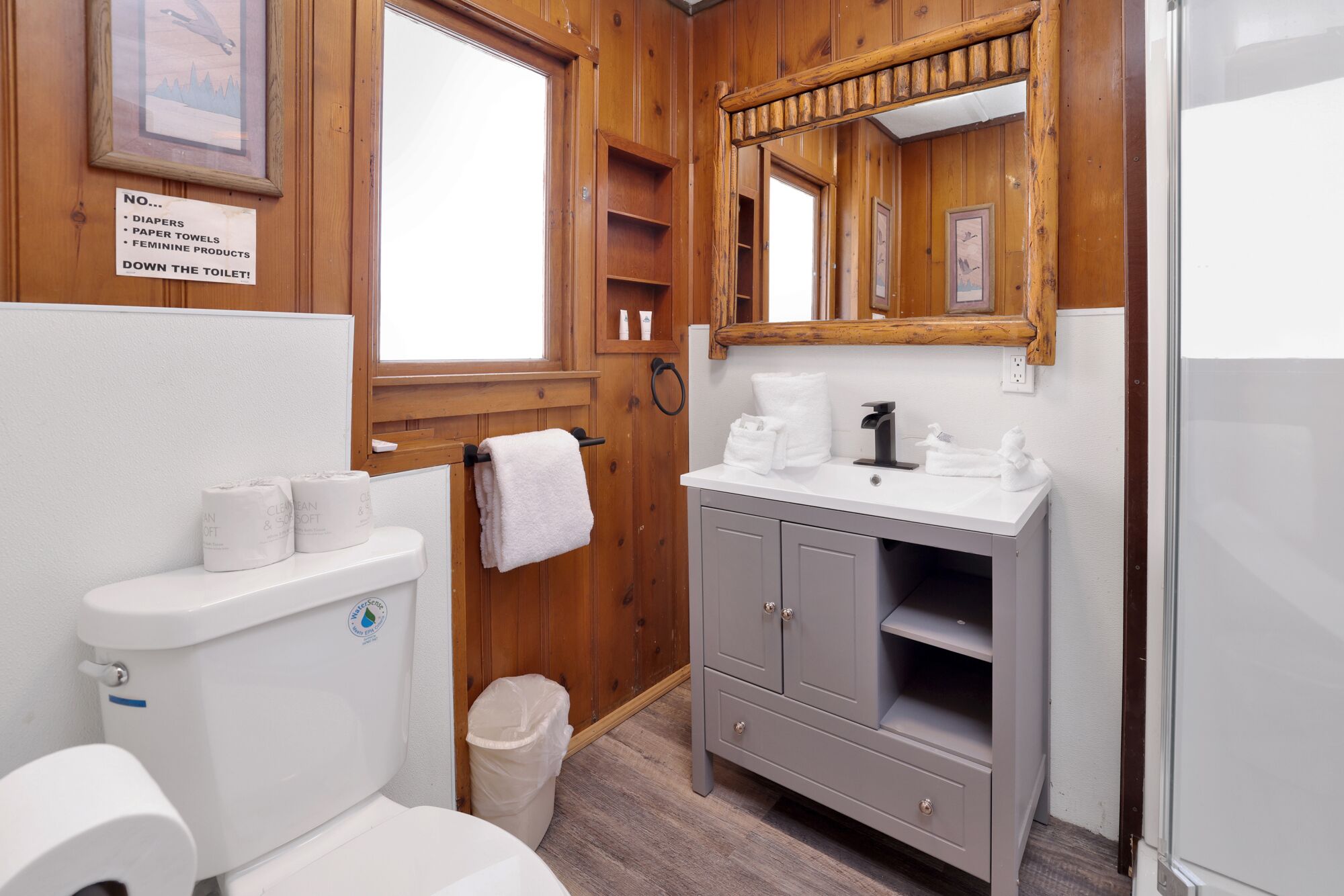 A bathroom with a shower, toilet, and sink.