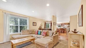 A living room with a sectional sofa, a coffee table, and a dining area in the background. - Fontana View Retreat - Free Whitewater Rafting Passes + Luxury Family Home w/ (Fontana Dam)