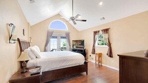 A bedroom with a large bed, a ceiling fan, a desk, and a window with curtains. - Fontana View Retreat - Free Whitewater Rafting Passes + Luxury Family Home w/ (Fontana Dam)