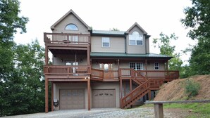 A two-story house with a balcony on the upper floor, a garage, and a staircase leading to the upper level. - Fontana View Retreat - Free Whitewater Rafting Passes + Luxury Family Home w/ (Fontana Dam)