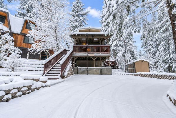 A snow-covered building with a wooden staircase leading to a balcony. - Comfy Cubby - Walk to Slopes, Fireplace, Deck (Big Bear Lake)