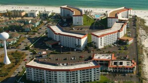 A coastal hotel with multiple buildings, a beach, and a tennis court. - El Matador 369 by Alicia Hollis Rentals Open Now FREE TICKETS! $300/Day (Fort Walton Beach)