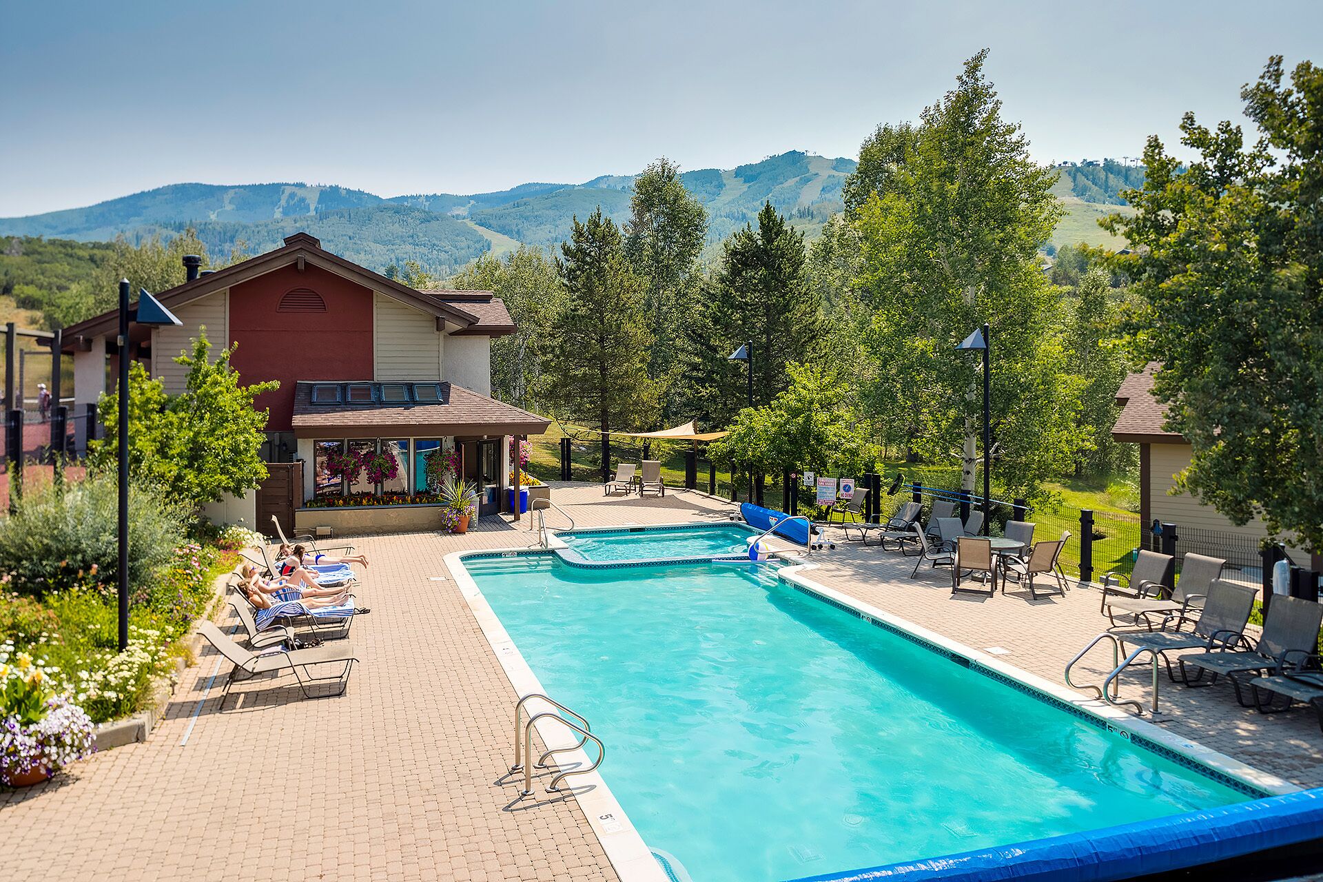 A swimming pool with lounge chairs and a view of mountains.