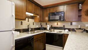 A kitchen with wooden cabinets, a microwave, a dishwasher, and a stove. - SM323 | Slopeside Condo | Hot Tub | Ski In/Walk Out | Free City Bus (Steamboat Springs)
