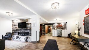 Ein modernes Wohnzimmer mit Steinwand, Kamin und einem flachbildfernseher, der darüber angebracht ist.