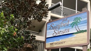 A hotel sign with a beach scene and a 'No Vacancy' notice. - Flip Flop Fun (Sanibel)