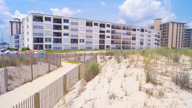 A multi-story hotel with a modern design, featuring balconies on each floor.