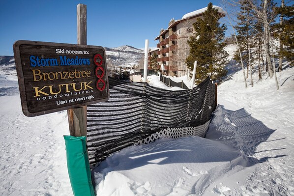 A sign indicating ski access to Storm Meadows, Bronzetree, and Kutuk with a warning to use at own risk.