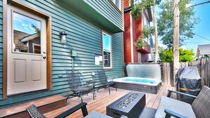 A patio with outdoor furniture, a hot tub, and a wooden deck.